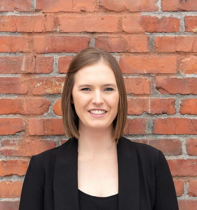 Professional portrait in front of red brick wall